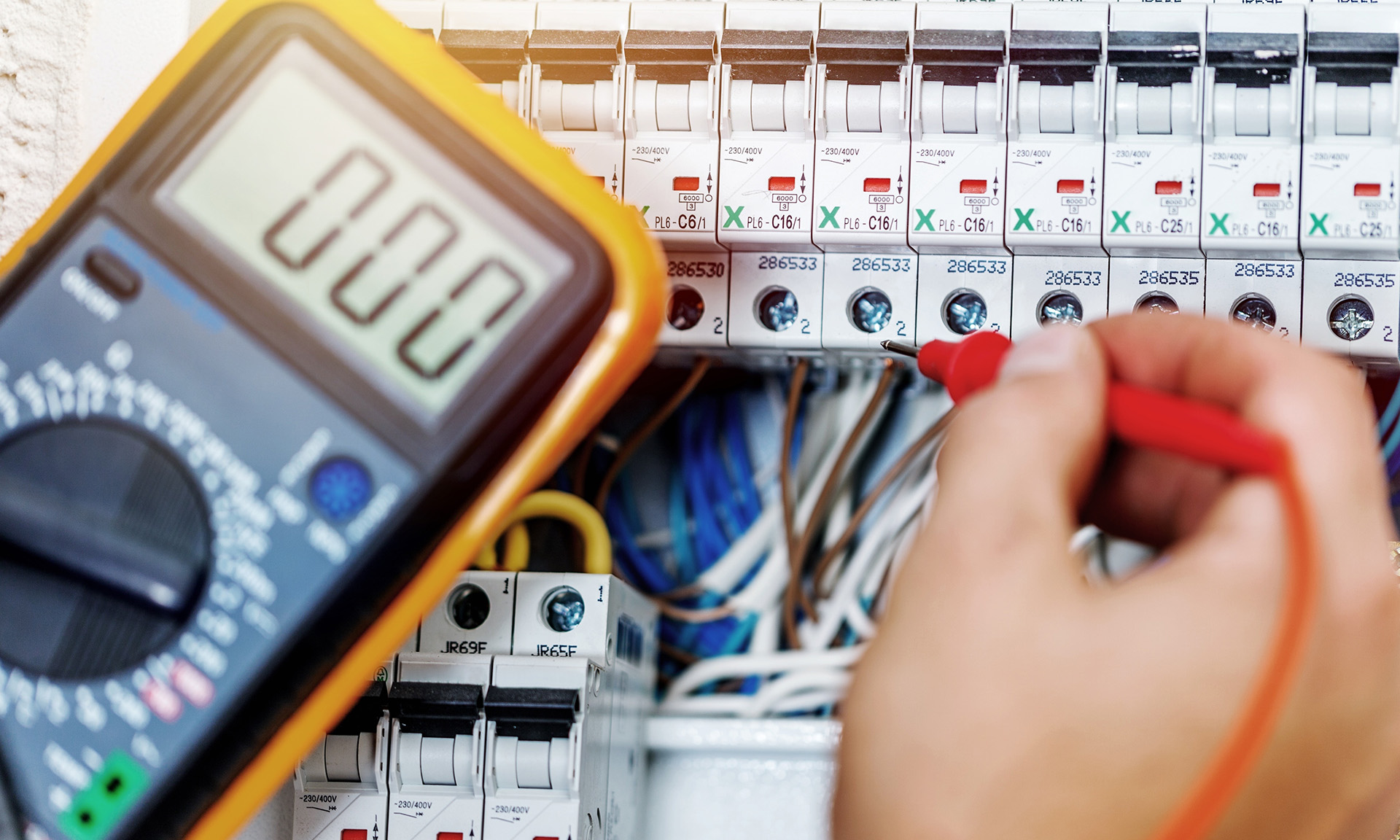 Electrician using a multimeter